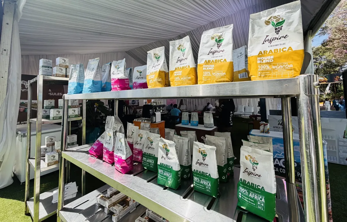 Inspire Africa Coffee roasted packs on a stand shelf: Arabica House Blend in yellow above, Arabica in green and Robusta in pink below