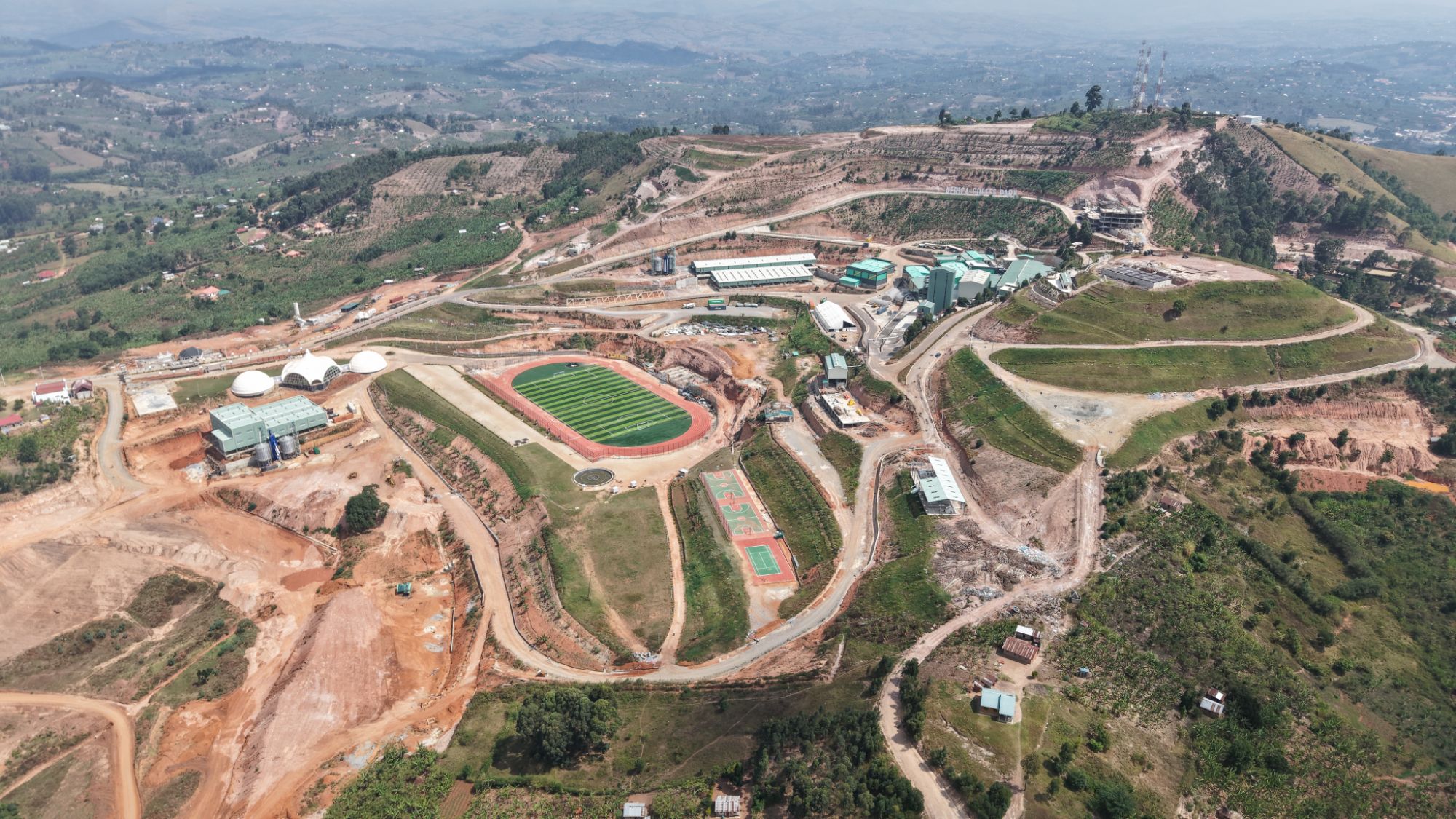 Aerial view over the Africa Coffee Park estate showing the factory, athletics track and highland blocks