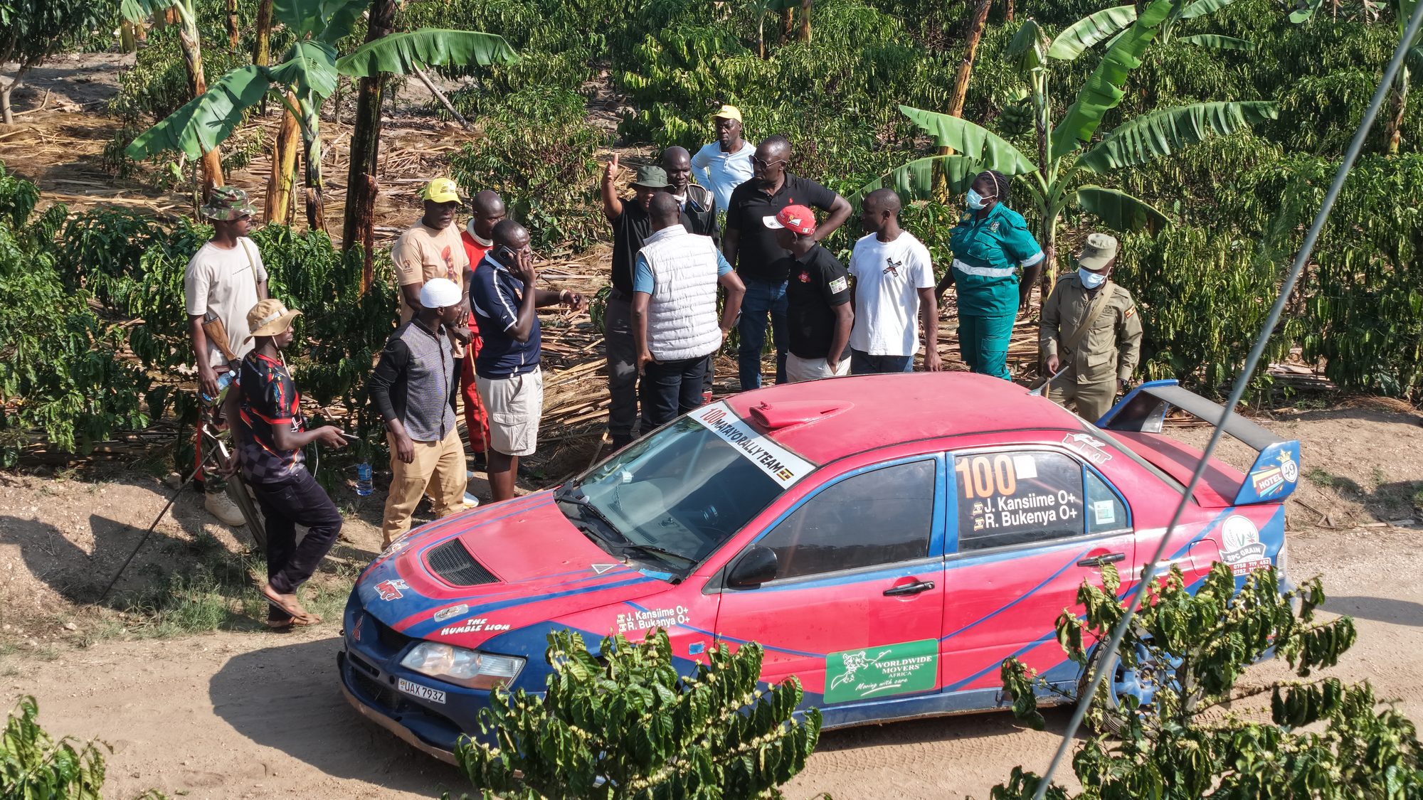 Rally car 100 on the estate stage with spectators lining the track beside young coffee