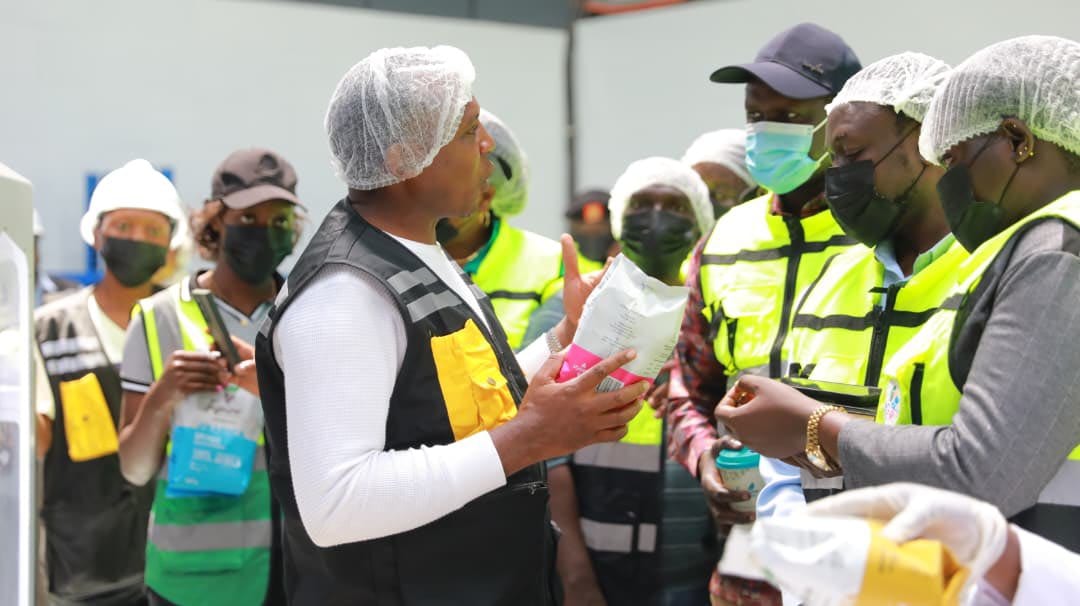 Members of the Parliamentary Committee on Presidential Affairs touring the Inspire Africa processing plant in high-visibility vests.