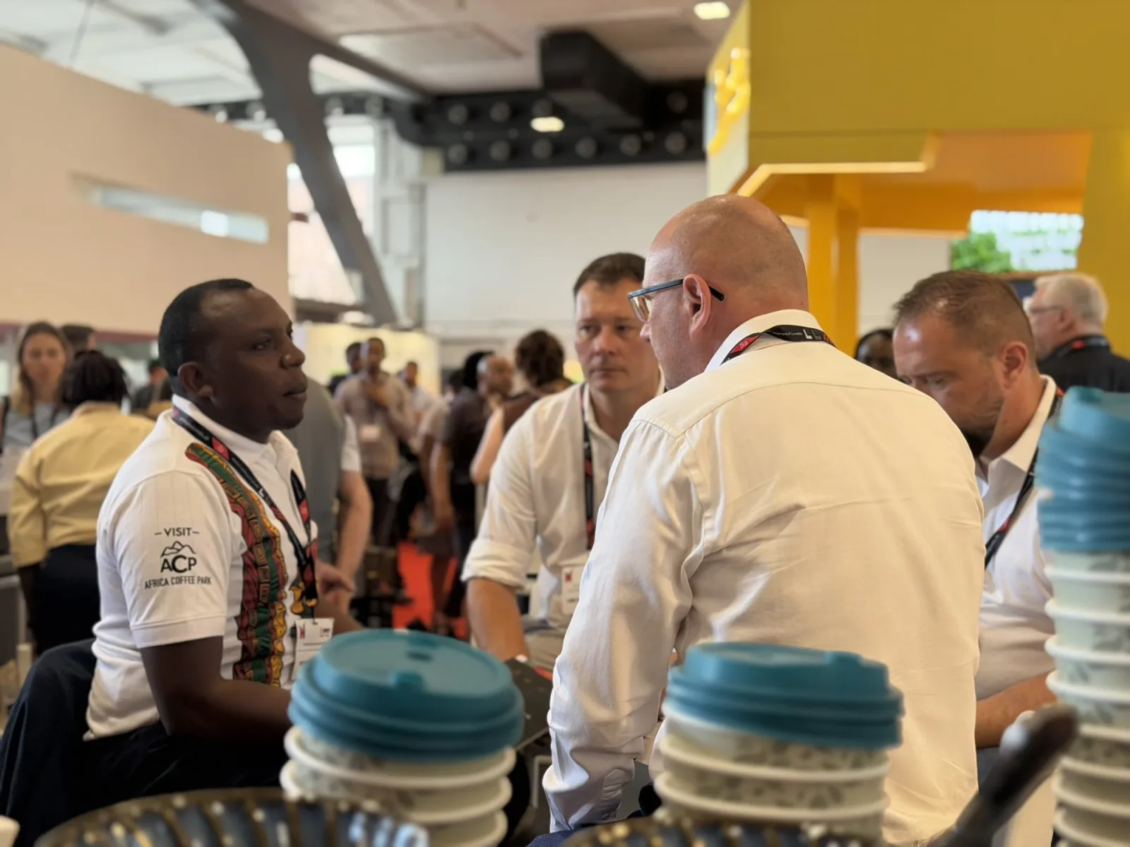 An Africa Coffee Park delegate in a Visit ACP shirt in discussion at the exhibition