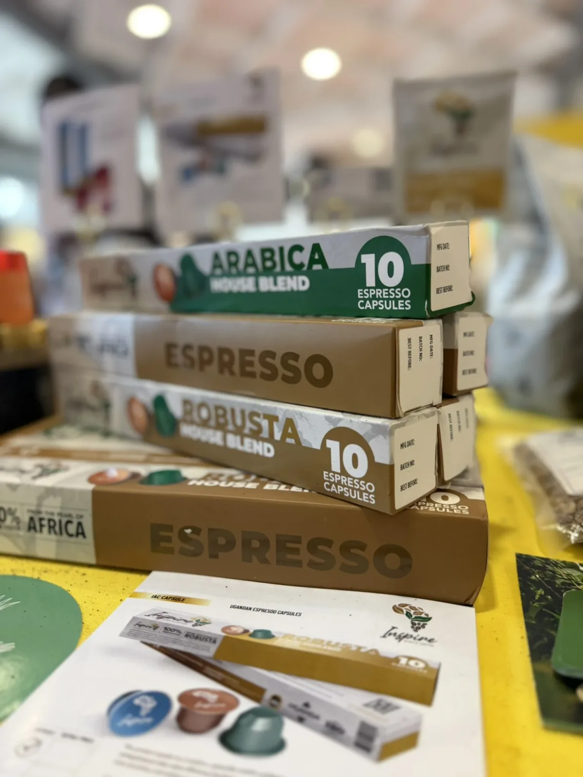 Inspire Africa Arabica, Robusta and Espresso House Blend capsule boxes stacked on the stand at World of Coffee Brussels.