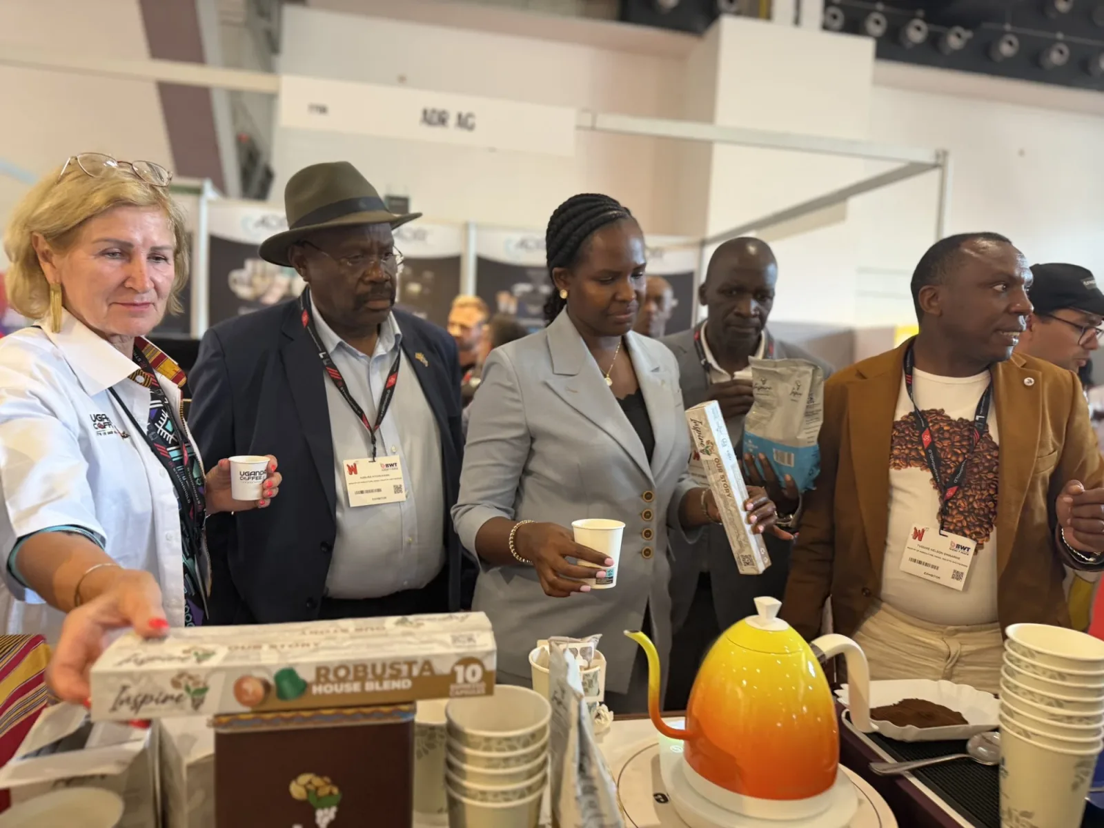 The Uganda delegation at the Africa Coffee Park booth holding Robusta House Blend capsules and roasted coffee packs