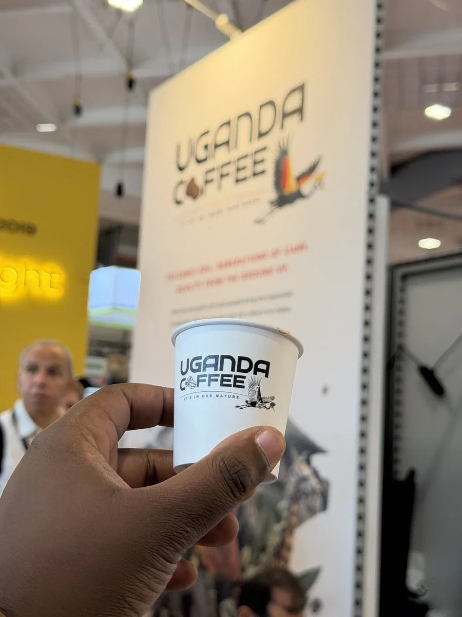 A Uganda Coffee branded cup held up at the Uganda Coffee stand, World of Coffee Brussels