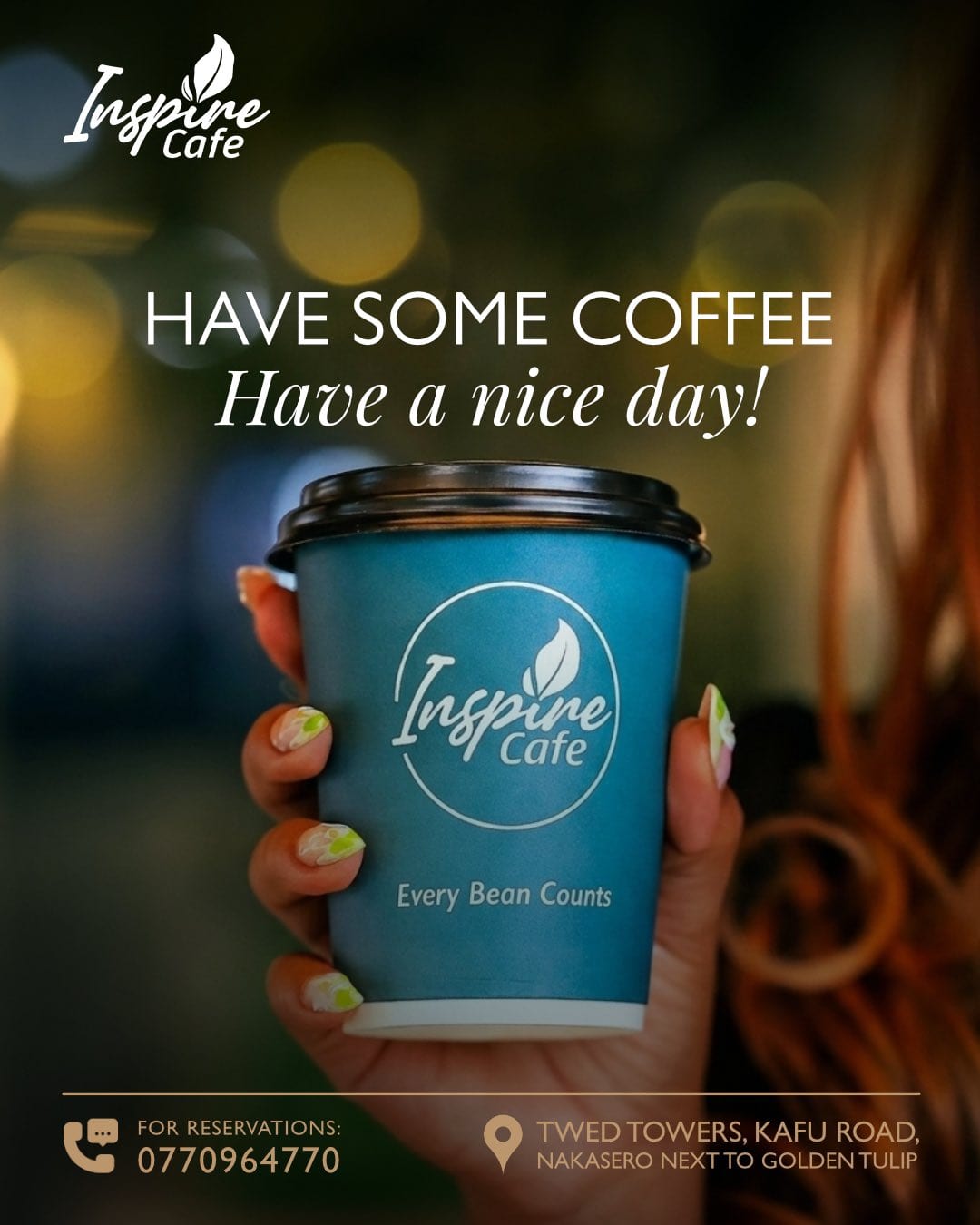 An Inspire Cafe takeaway cup — “Every Bean Counts” — held in front of warm evening light